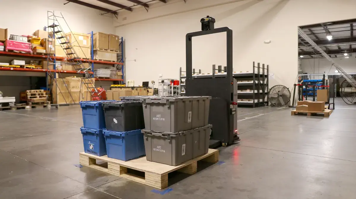 A PickPallet autonomous pallet mover navigating a racked warehouse aisle